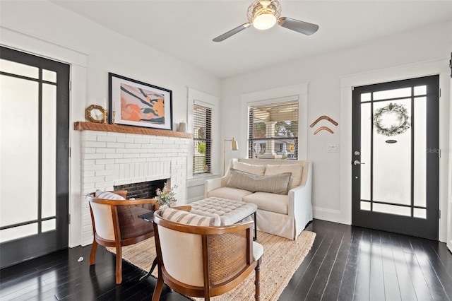 interior space featuring ceiling fan, a brick fireplace, and dark hardwood / wood-style flooring