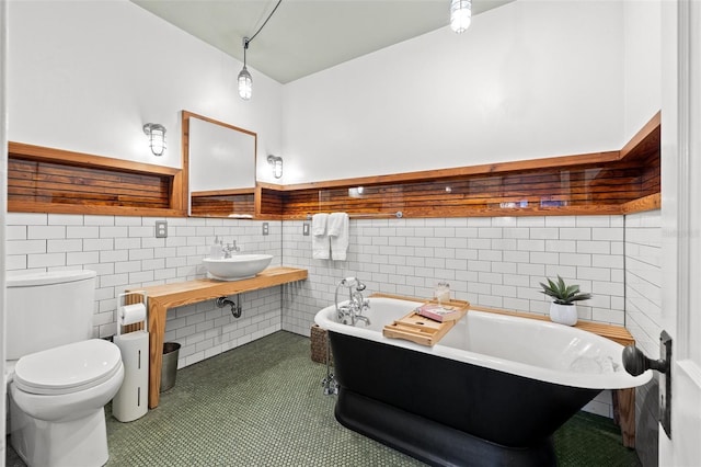 bathroom featuring sink, tile walls, a bathing tub, tile patterned floors, and toilet