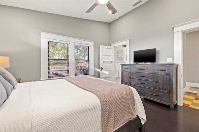 bedroom featuring ceiling fan, dark hardwood / wood-style floors, and a high ceiling