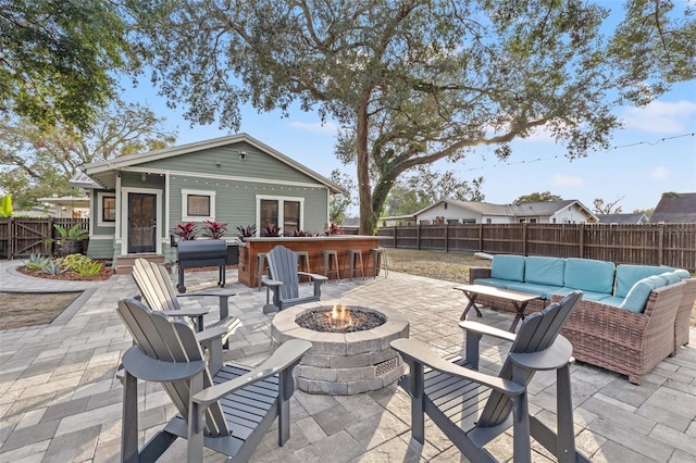 view of patio / terrace with an outdoor structure, an outdoor living space with a fire pit, and an outdoor bar