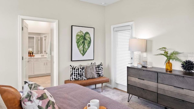 bedroom with light carpet and connected bathroom