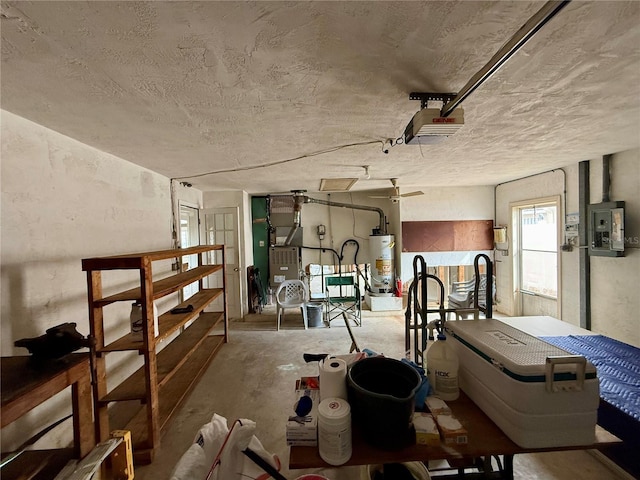 interior space with heating unit, a garage door opener, gas water heater, and electric panel