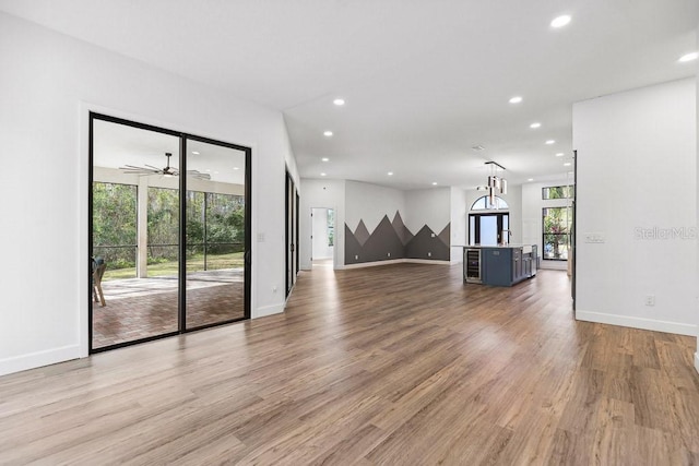 unfurnished living room with ceiling fan and light hardwood / wood-style floors