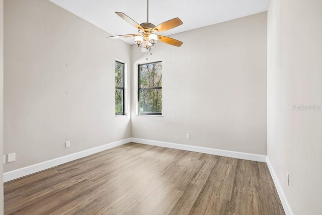 spare room with hardwood / wood-style floors and ceiling fan