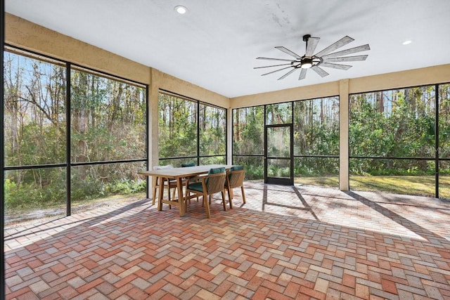 unfurnished sunroom with ceiling fan