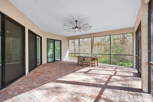 unfurnished sunroom with a wealth of natural light and ceiling fan