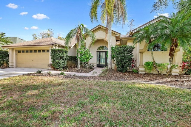 mediterranean / spanish-style house featuring a garage and a front yard