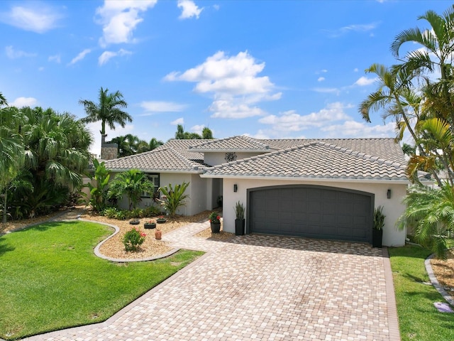 mediterranean / spanish-style home with a garage and a front lawn