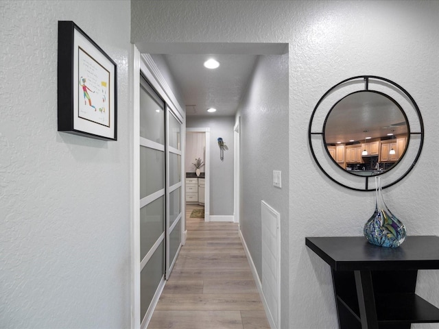 hallway with light hardwood / wood-style flooring