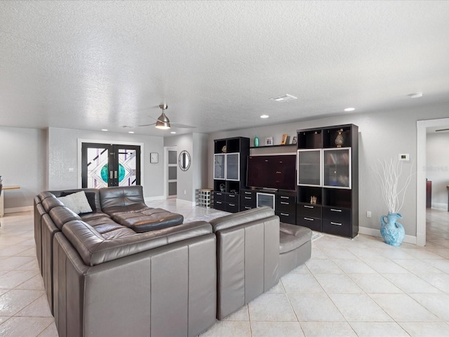 tiled living room featuring ceiling fan and a textured ceiling