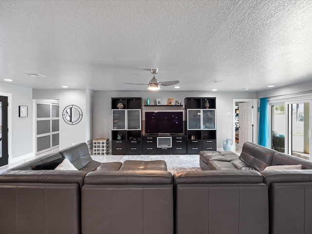 living room featuring a textured ceiling and ceiling fan