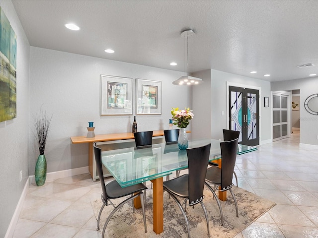 dining space with light tile patterned floors and a textured ceiling