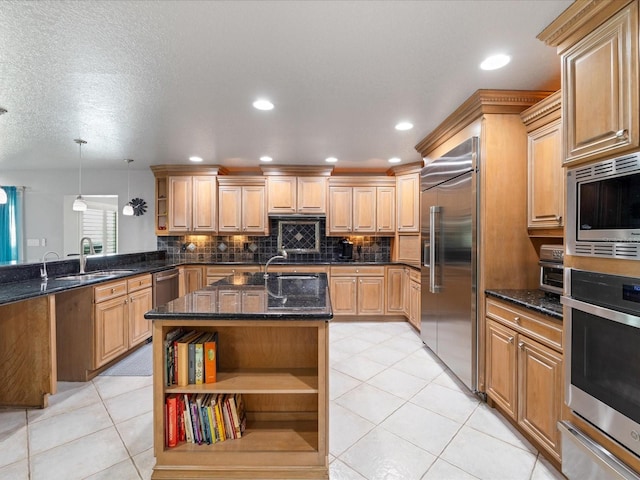 kitchen featuring sink, built in appliances, light tile patterned floors, pendant lighting, and a kitchen island with sink