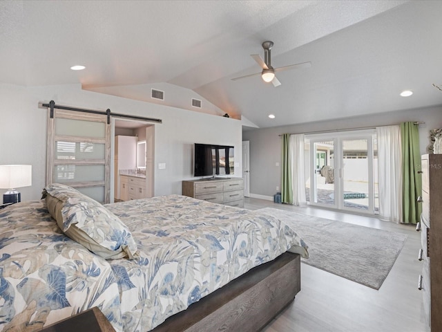 bedroom featuring ceiling fan, a barn door, vaulted ceiling, and access to exterior