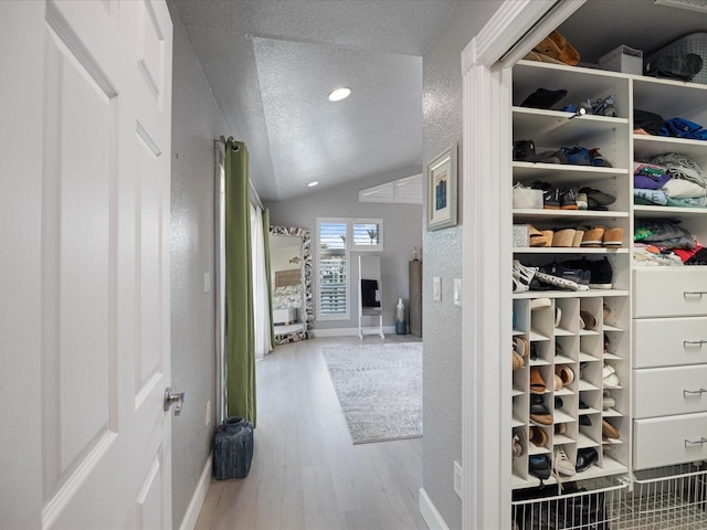 walk in closet featuring light hardwood / wood-style flooring and vaulted ceiling