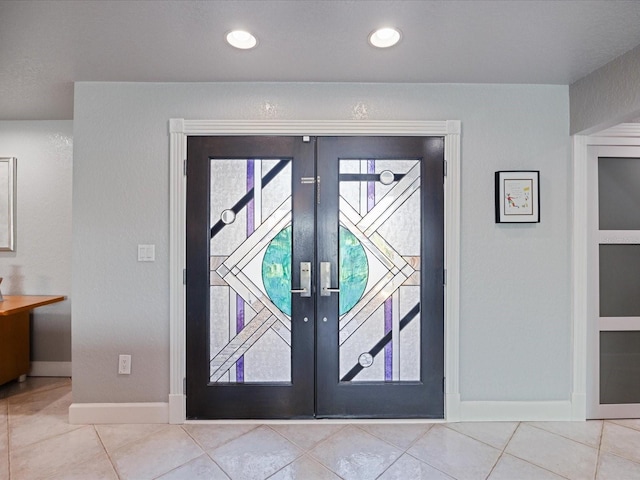 foyer with french doors and light tile patterned floors