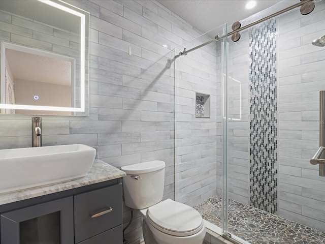 bathroom with vanity, tile walls, an enclosed shower, and toilet