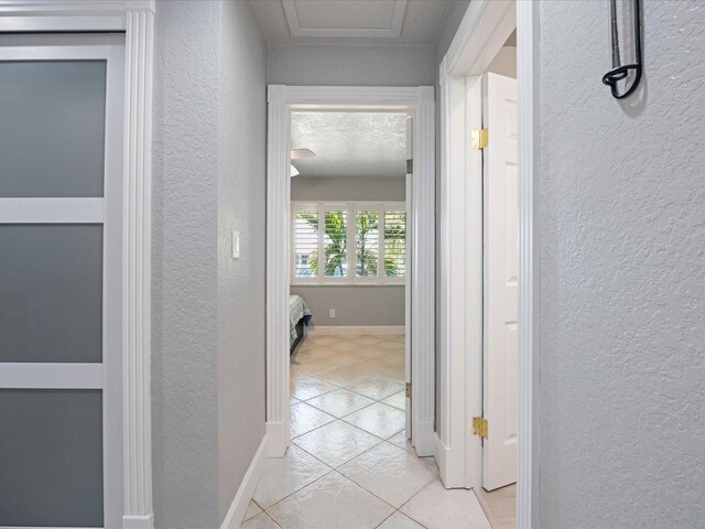 hall with light tile patterned floors and a textured ceiling