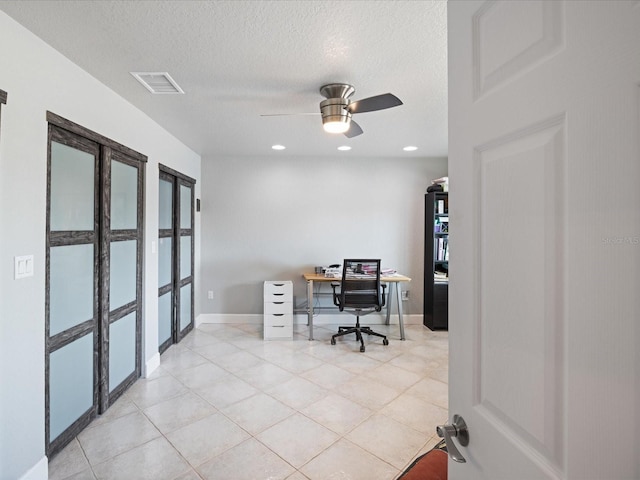 tiled office space with ceiling fan and a textured ceiling