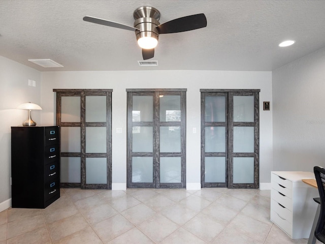 home office featuring ceiling fan and a textured ceiling