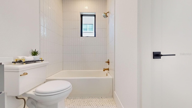 bathroom featuring tiled shower / bath, toilet, and tile patterned flooring