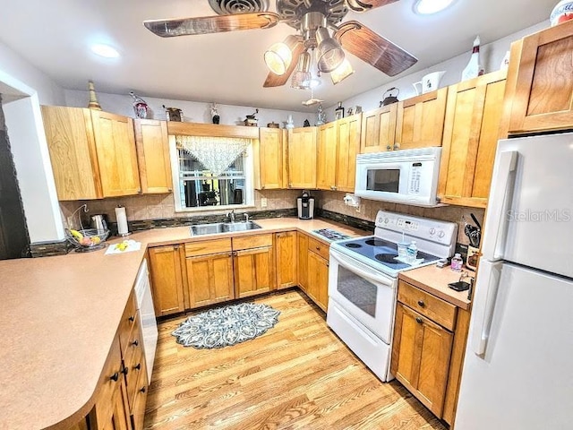 kitchen with sink, white appliances, light hardwood / wood-style flooring, ceiling fan, and decorative backsplash