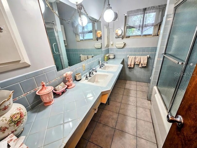 bathroom with enclosed tub / shower combo, vanity, tile patterned flooring, and tile walls