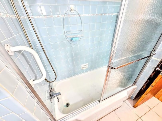 bathroom featuring tile patterned flooring and combined bath / shower with glass door