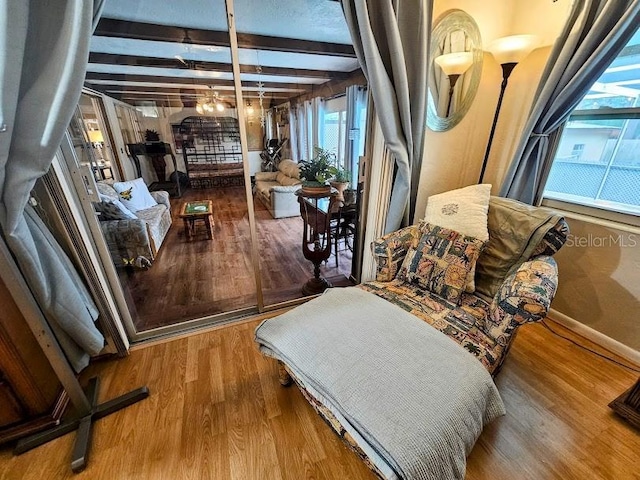 living area with hardwood / wood-style flooring and beam ceiling