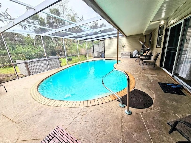 view of swimming pool featuring a patio and glass enclosure