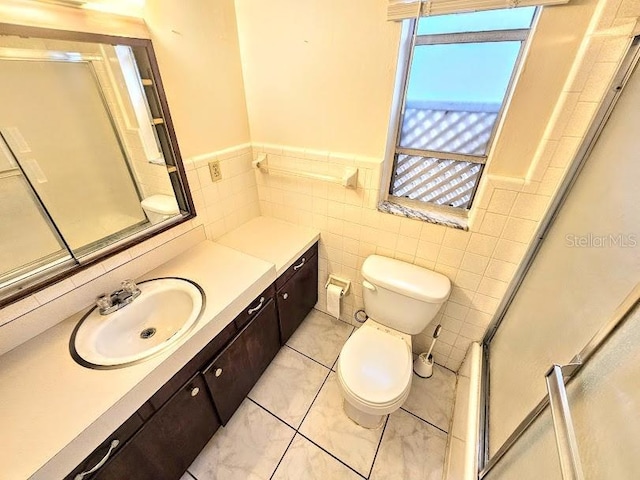 bathroom featuring vanity, tile walls, toilet, and walk in shower