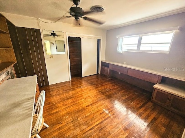 unfurnished bedroom with dark wood-type flooring, a closet, and ceiling fan