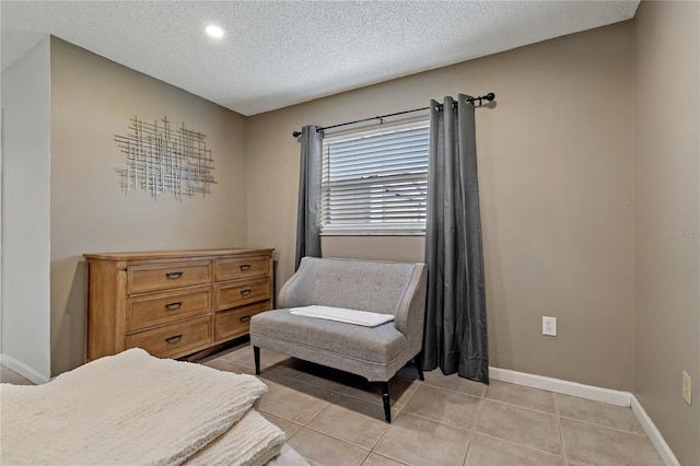 living area with a textured ceiling and light tile patterned flooring