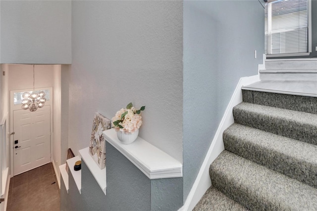 staircase featuring a chandelier and tile patterned flooring