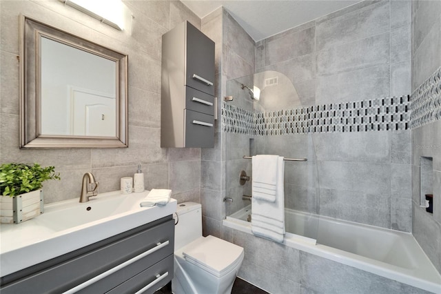 full bathroom with shower / bath combo, tile walls, backsplash, vanity, and toilet