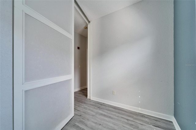 spare room featuring a textured ceiling and light wood-type flooring