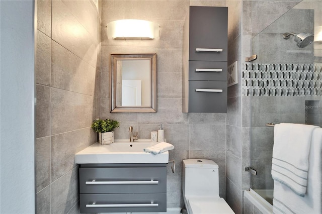 full bathroom with tile walls, vanity, tub / shower combination, and toilet