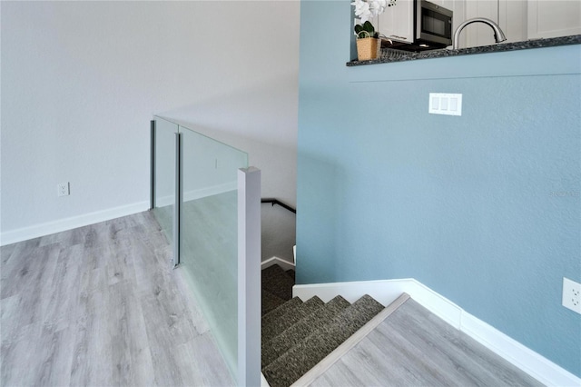 stairs with sink and hardwood / wood-style flooring