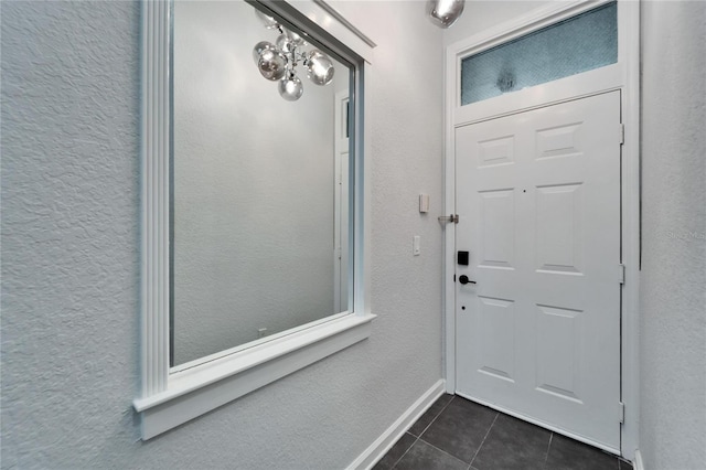 foyer entrance featuring dark tile patterned flooring