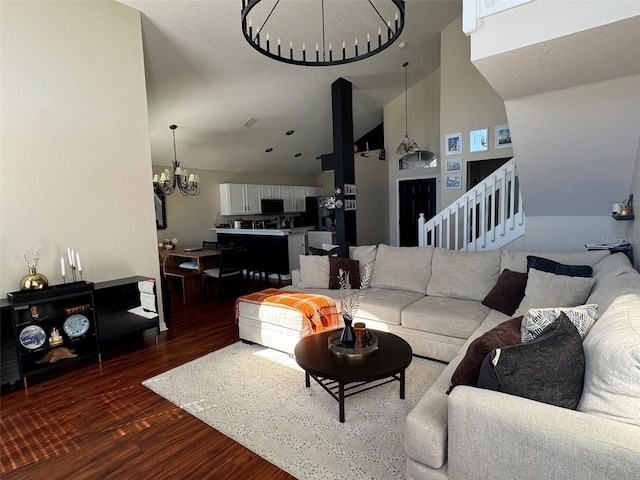 living room featuring dark hardwood / wood-style flooring, a chandelier, and high vaulted ceiling