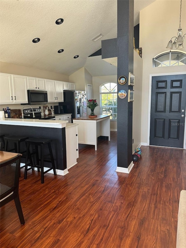 kitchen with white cabinetry, a breakfast bar, kitchen peninsula, and appliances with stainless steel finishes