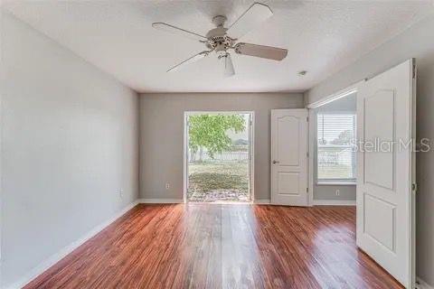 empty room featuring ceiling fan, hardwood / wood-style floors, and a wealth of natural light