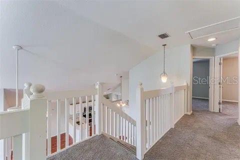 corridor featuring lofted ceiling and carpet flooring