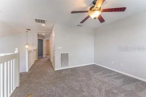 empty room with lofted ceiling and dark colored carpet