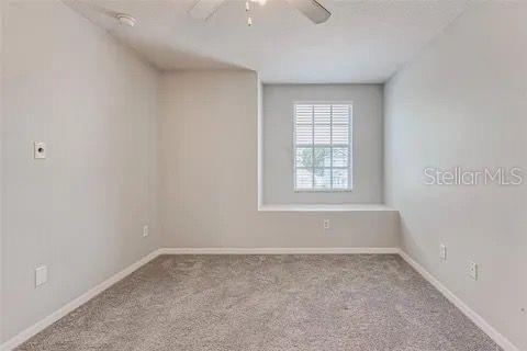 empty room featuring ceiling fan and light carpet