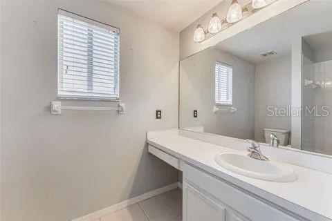 bathroom featuring tile patterned flooring, vanity, and toilet