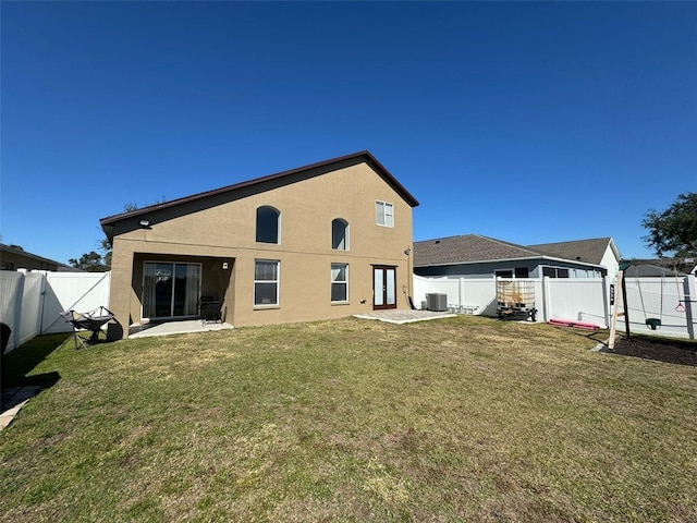 rear view of property featuring cooling unit, a yard, and a patio area