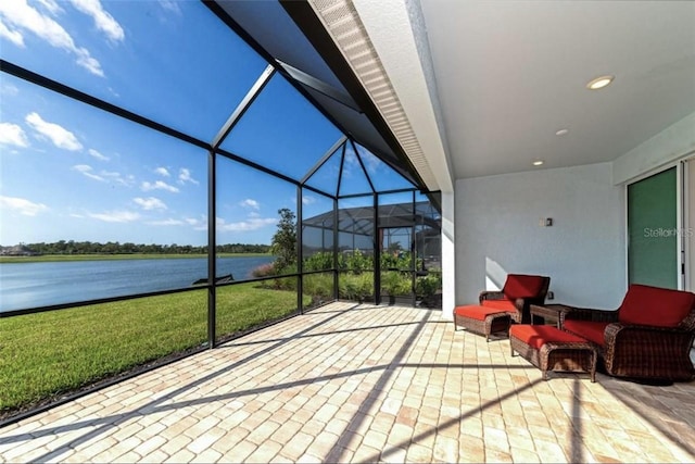 view of patio / terrace with a water view, an outdoor hangout area, and glass enclosure