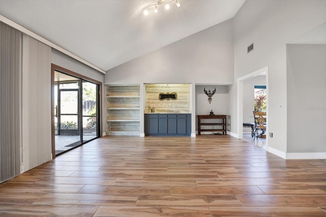 unfurnished living room featuring high vaulted ceiling