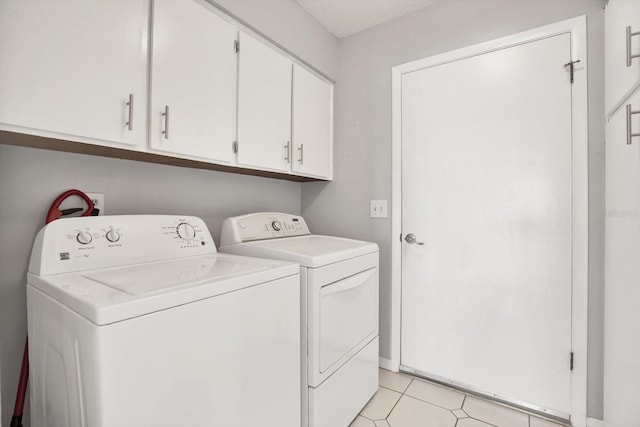 laundry area with cabinets, light tile patterned floors, and independent washer and dryer